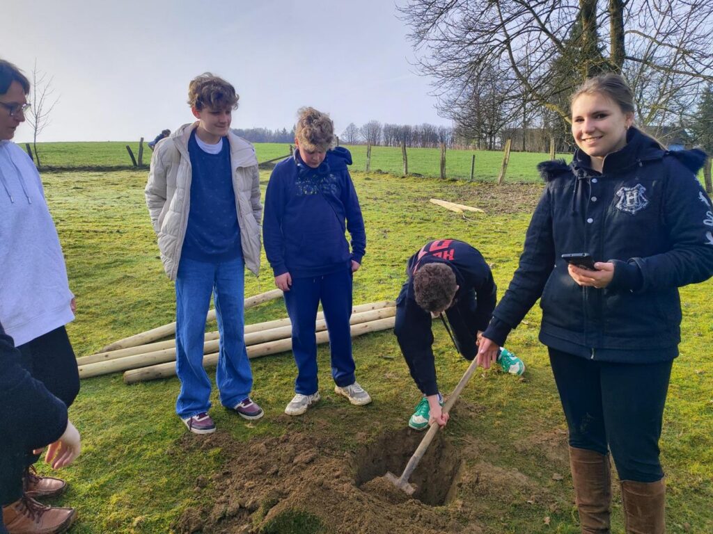Schüler pflanzen einen Baum und arbeiten gemeinschaftlich im Freien.