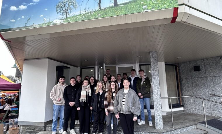 Gruppe von Schülerinnen und Schülern vor einem Gebäudeeingang.