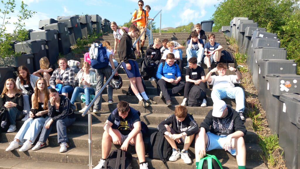 Schüler sitzen auf Treppen und entspannen sich in der Sonne.