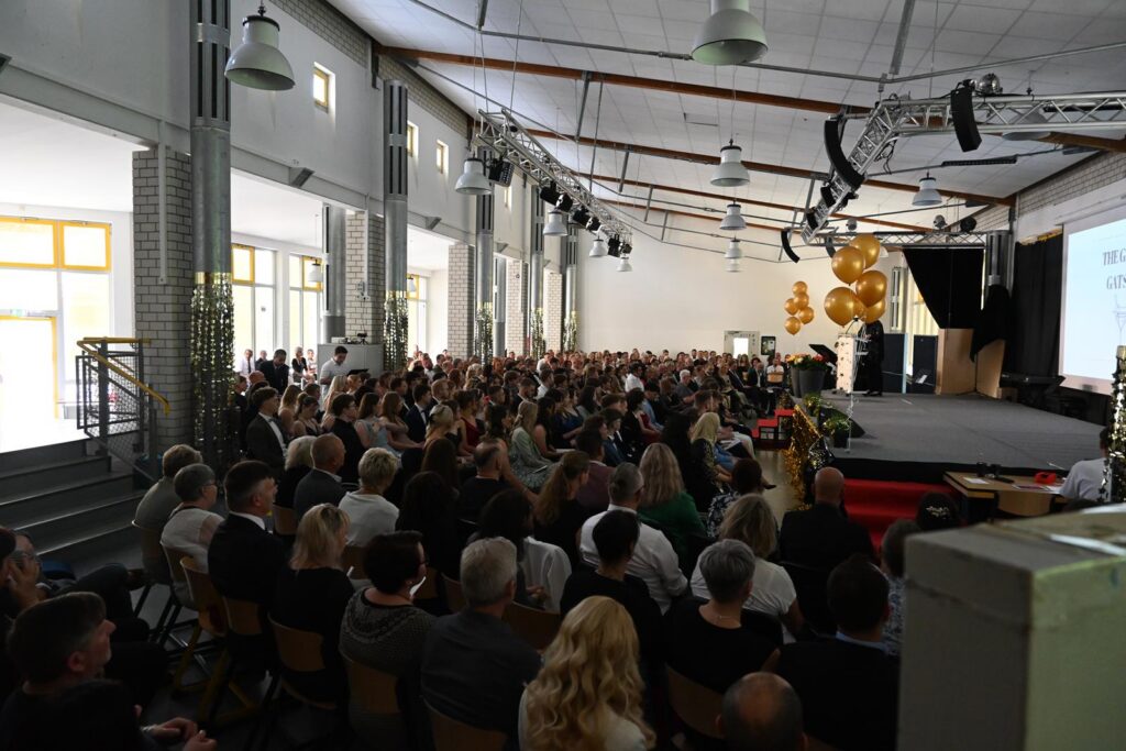 Menschenmenge in einem großen Saal bei einer Veranstaltung.