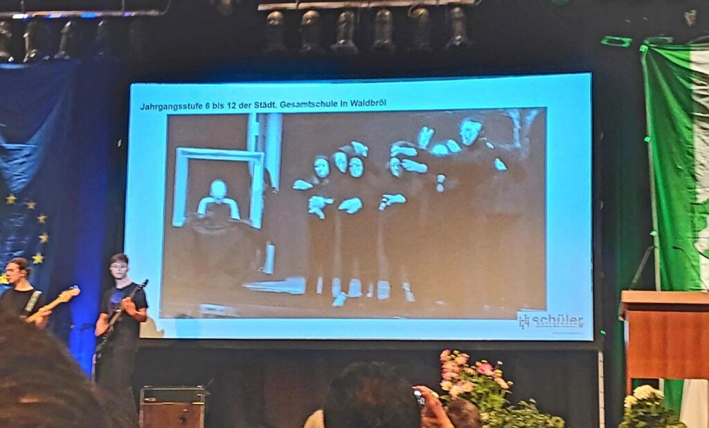 Eine Präsentation mit einer Schwarz-Weiß-Fotoaufnahme und Musiker im Vordergrund.