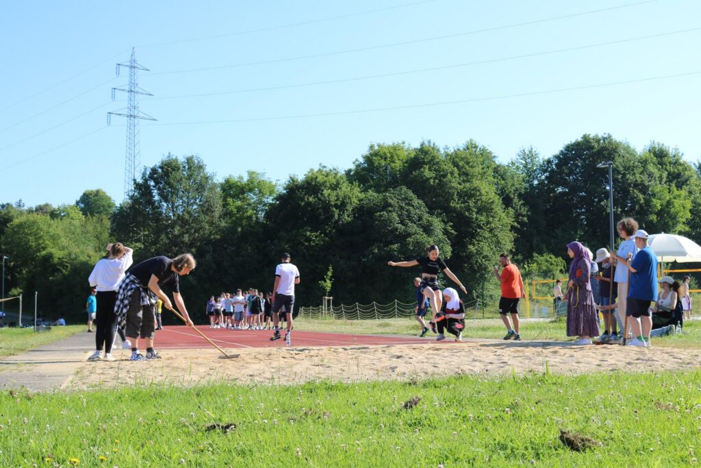 Schüler beim Leichtathletiktraining auf einem Sportplatz.
