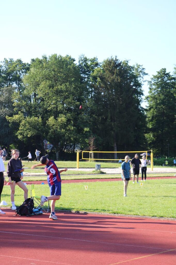 Sportplatz mit verschiedenen Schülern, die sich auf Aktivitäten vorbereiten.
