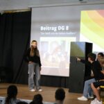 Schüler führen auf einer Bühne eine Theateraufführung vor.