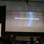 Eine Präsentation mit dem Titel "Classroom-Challenge" auf einer Leinwand.
