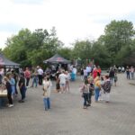 Schüler und Besucher auf einem Schulhof bei einer Veranstaltung mit Ständen.