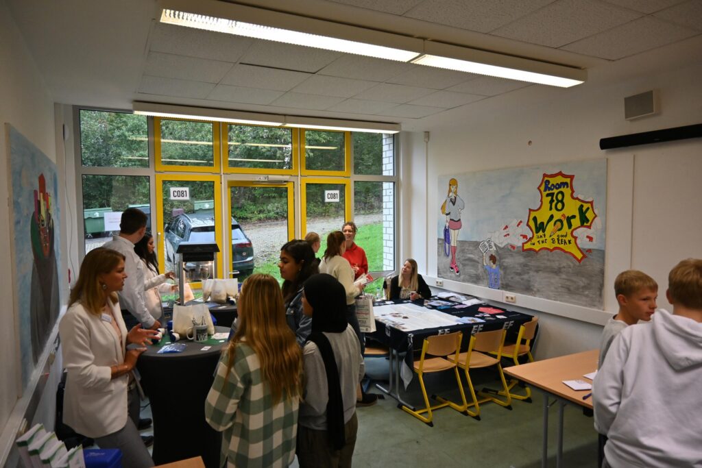 Schüler und Lehrer in einem Klassenraum bei einer Informationsveranstaltung.