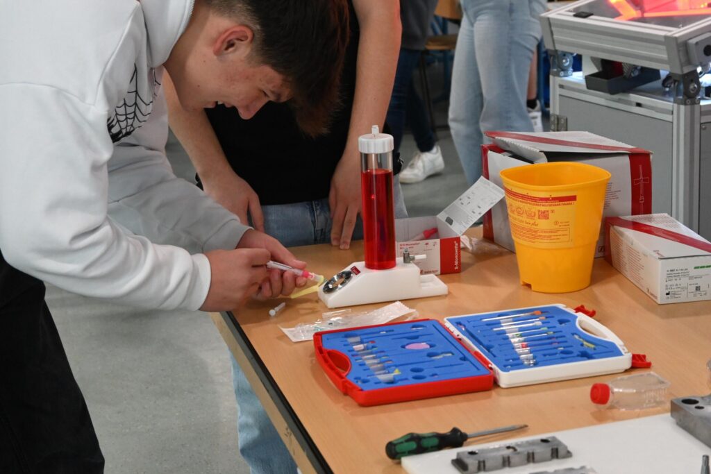 Schüler arbeitet mit einem Set zur Durchführung von Experimenten am Tisch.