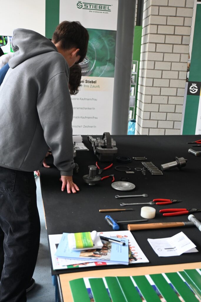 Schüler arbeiten an einem Tisch mit Werkzeugen und Materialien.