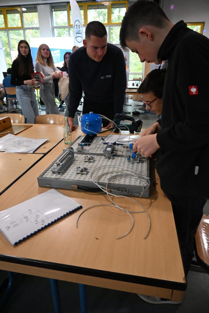 Schüler arbeiten an einem technischen Projekt an einem Tisch.