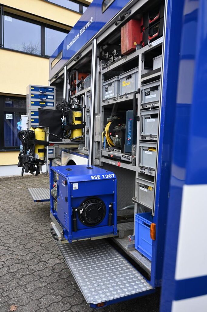 Blick auf das offene Fach eines Einsatzfahrzeugs mit Technik und Geräten.