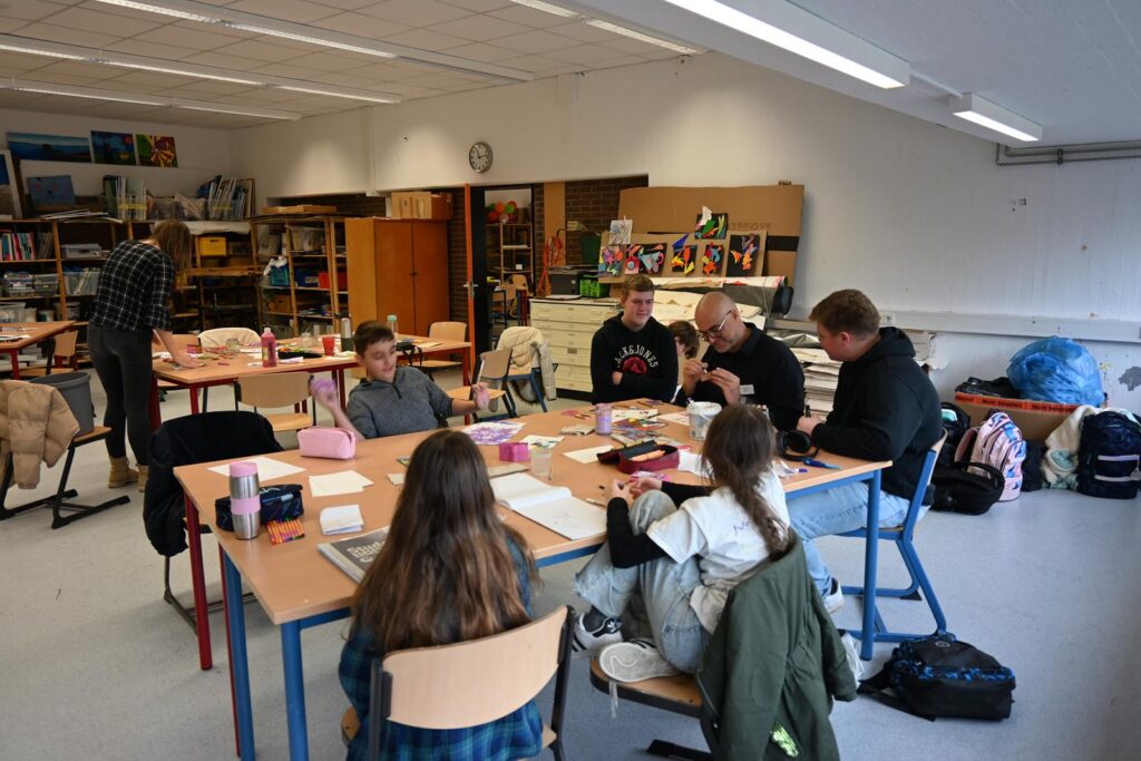 Gruppe von Schülern an einem Tisch in einem Klassenzimmer.