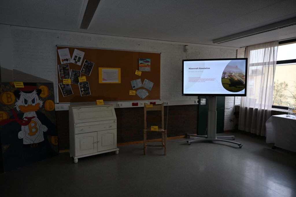Ein Klassenraum mit einer Präsentation, Pinnwand und Möbeln.