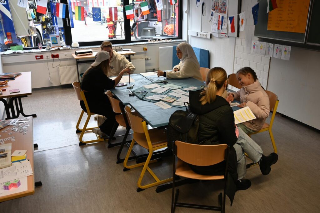 Schülerinnen arbeiten an einem Tisch in einem Klassenraum.