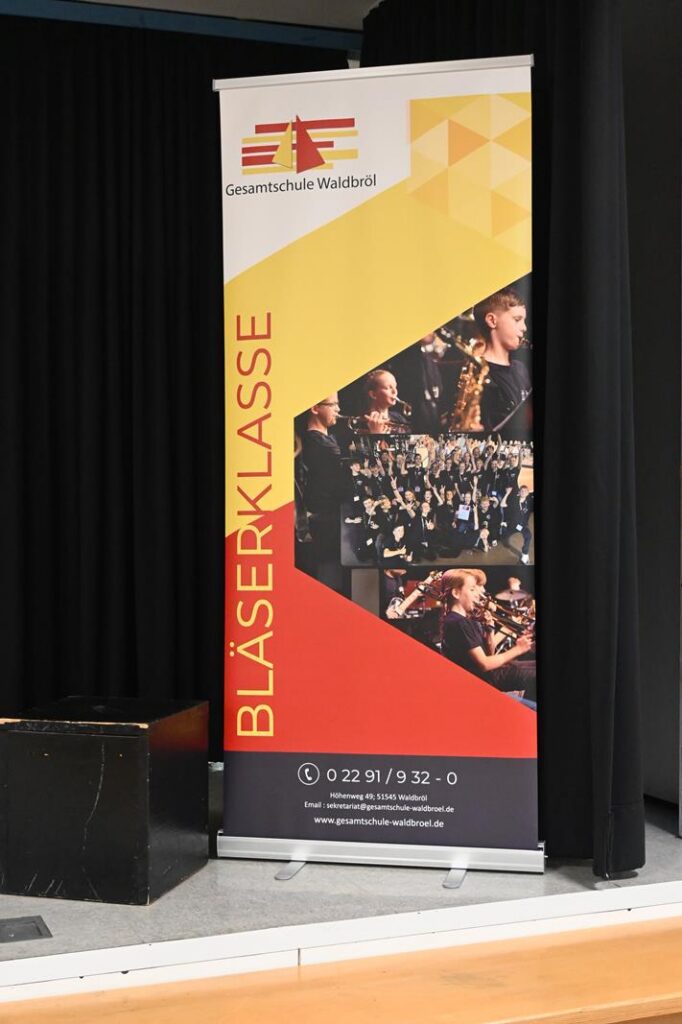 Banner der Bläserklasse mit Fotos von Blasmusikern und Schule.