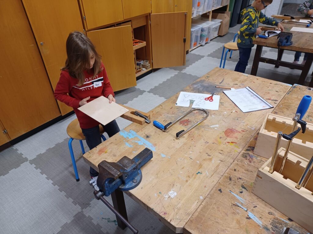 Ein Mädchen arbeitet in einer Werkstatt an einem Holzprojekt.