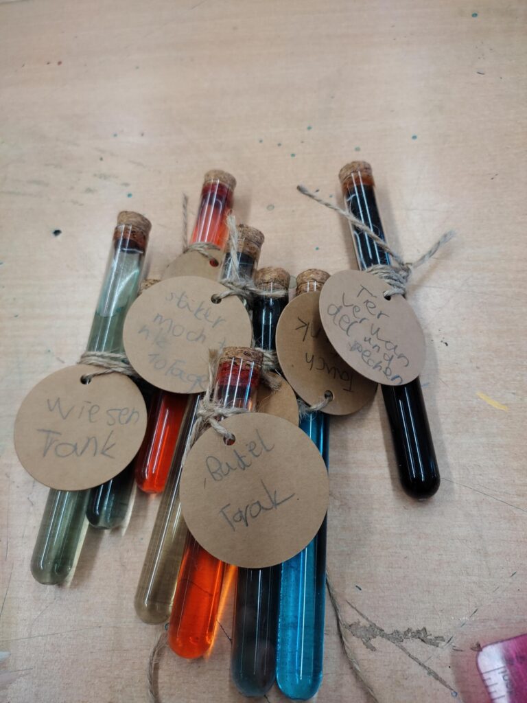 Reagenzgläser mit bunten Flüssigkeiten und beschrifteten Etiketten.