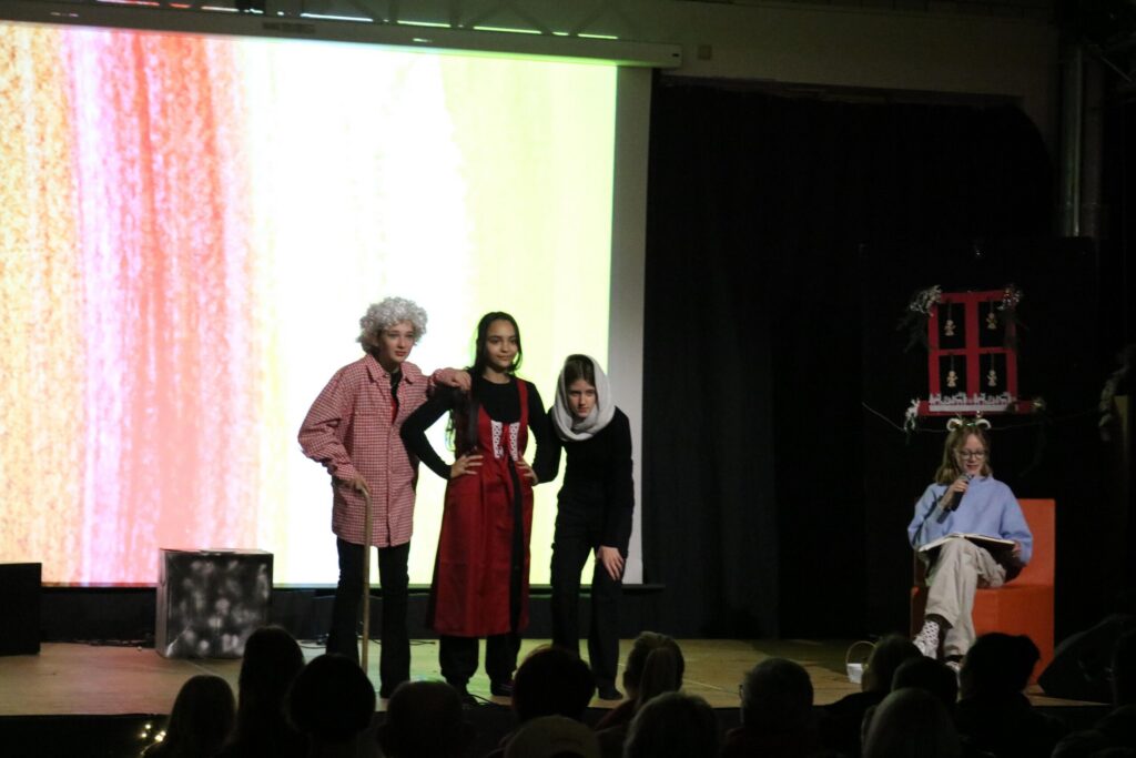 Drei Schauspielerinnen auf der Bühne während einer Theateraufführung.