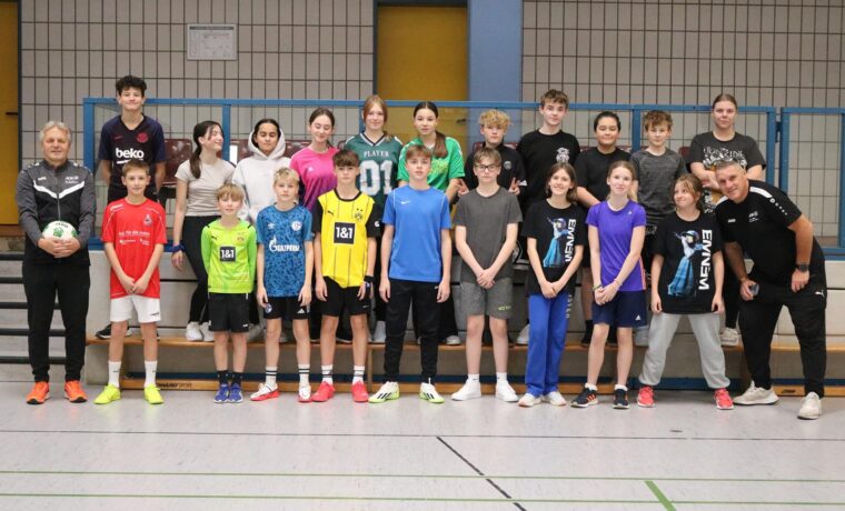 Gruppe von Jugendlichen in Sportkleidung, lächelnd in einer Turnhalle.