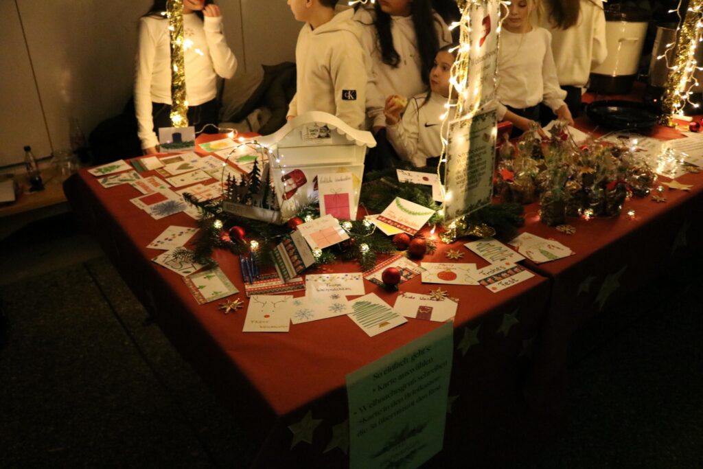 Weihnachtlicher Stand mit Karten, Deko und Lichtern.