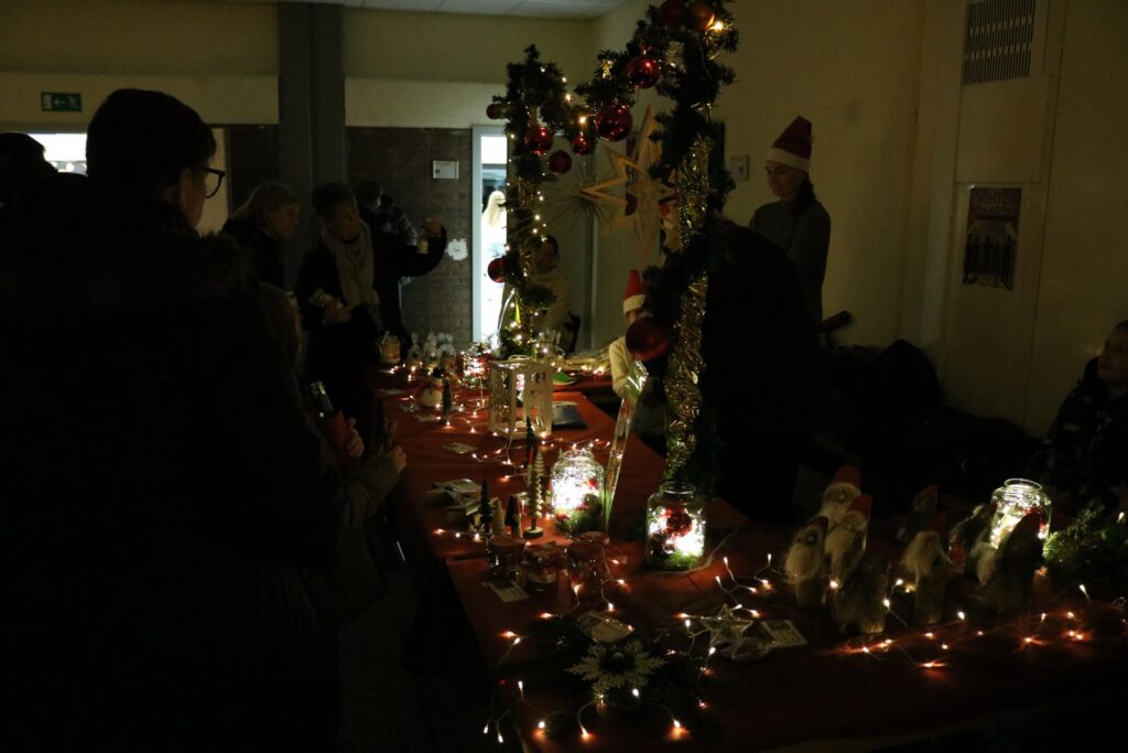 Weihnachtlicher Tisch mit Dekoration und Kerzen in einem festlichen Raum.