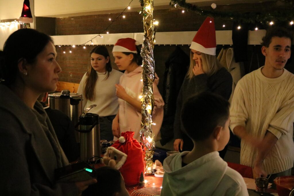 Weihnachtsfeier mit Gästen in festlicher Kleidung und Weihnachtsdekoration.