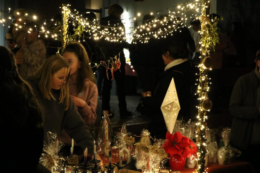 Weihnachtsmarkt mit leuchtenden Lichtern und festlich geschmückten Ständen.