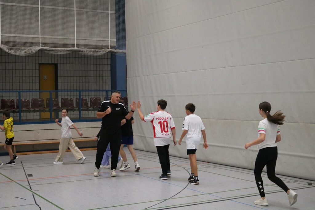 Schüler spielen in einer Sporthalle, jubeln und feiern gemeinsam.