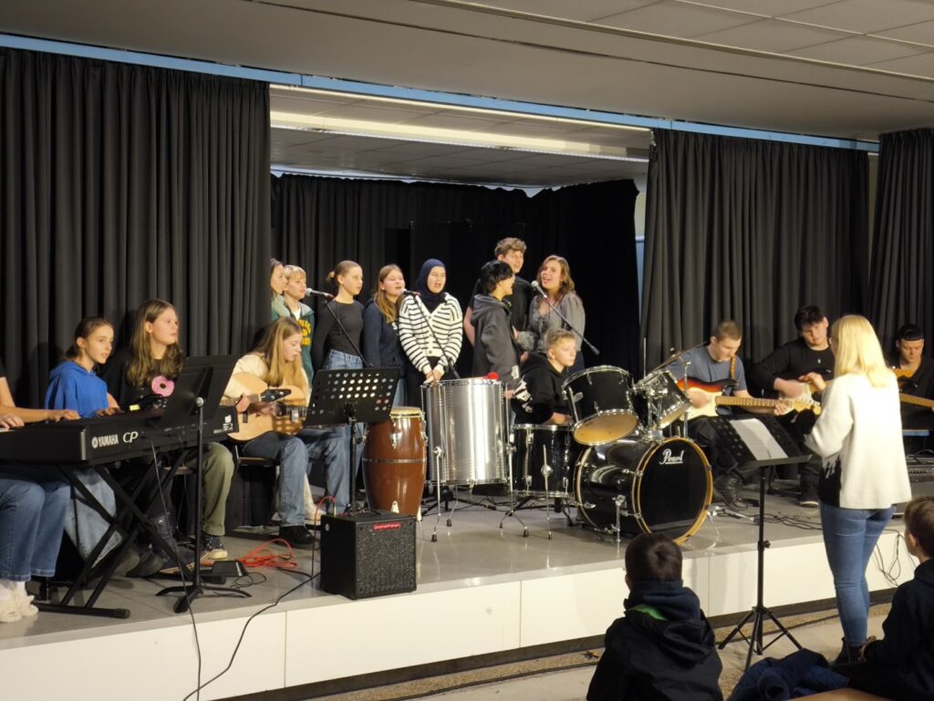 Schüler führen auf einer Bühne mit verschiedenen Instrumenten auf.