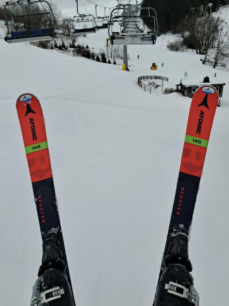 Sicht von einem Skilift auf verschneite Pisten und Skier.