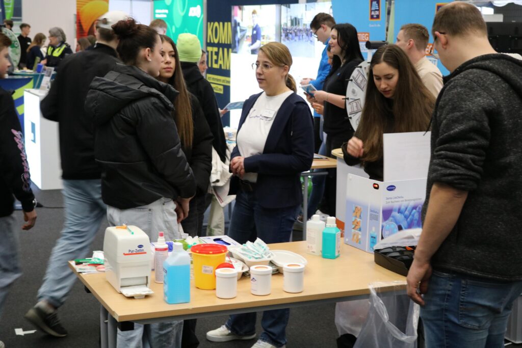 Messebesucher an einem Stand mit verschiedenen Produkten und Materialien.