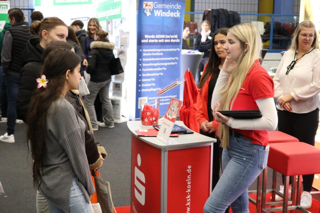 Messestand mit Personen, die Informationen austauschen.