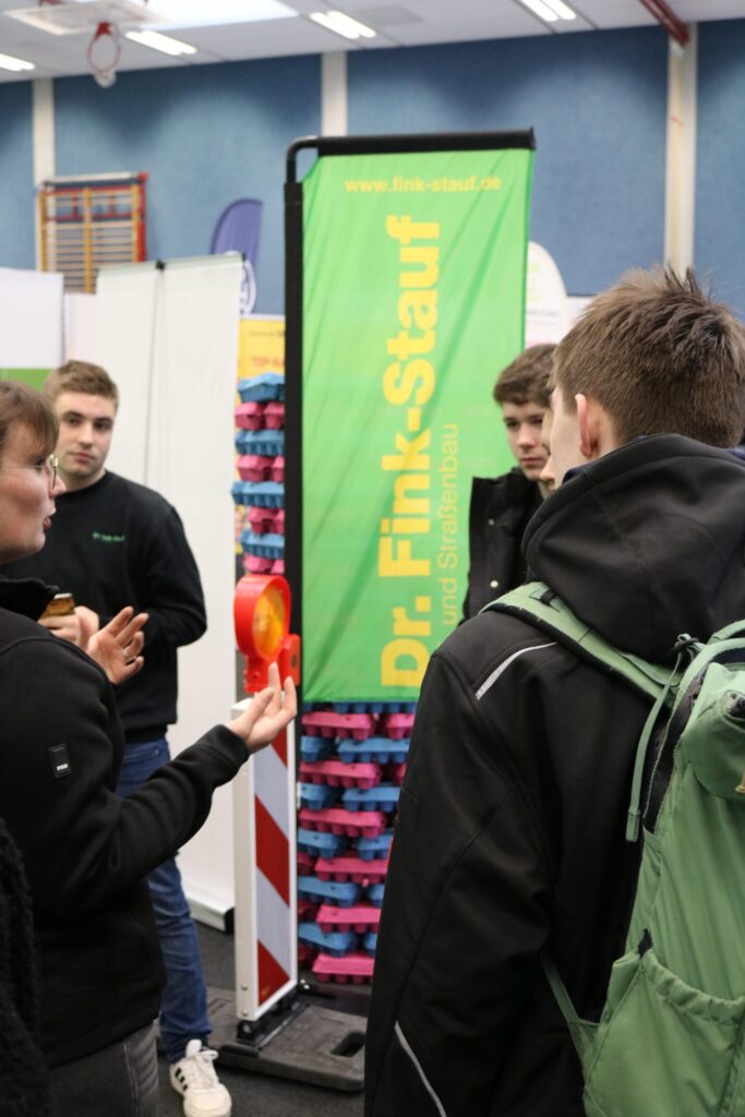 Schüler diskutieren am Stand von Dr. Fink-Stauf auf einer Messe.