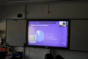 Präsentation über soziale Medien auf einem Bildschirm im Klassenzimmer.