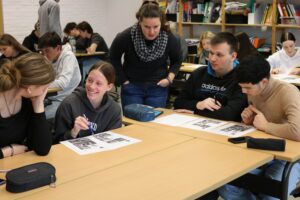 Schüler arbeiten gemeinsam an einem Tisch in einem Klassenzimmer.