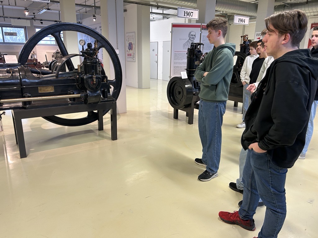 Schüler betrachten historische Maschinen in einem Museum.