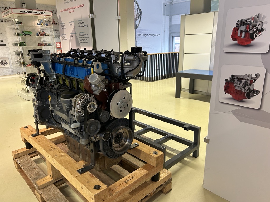 Ein Motor auf einer Holzpalette in einem Ausstellungsraum.
