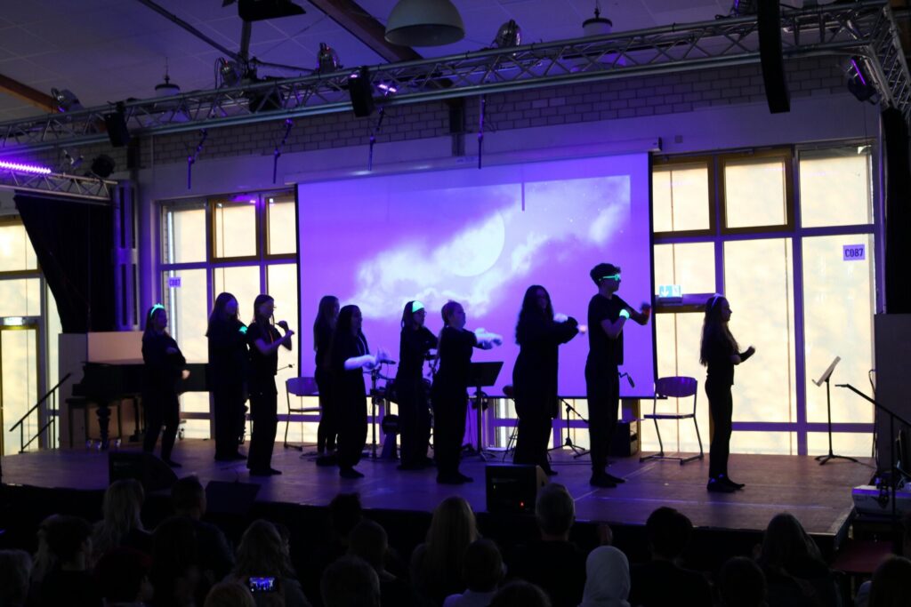 Eine Gruppe von Personen steht auf einer Bühne und spielt Instrumente.