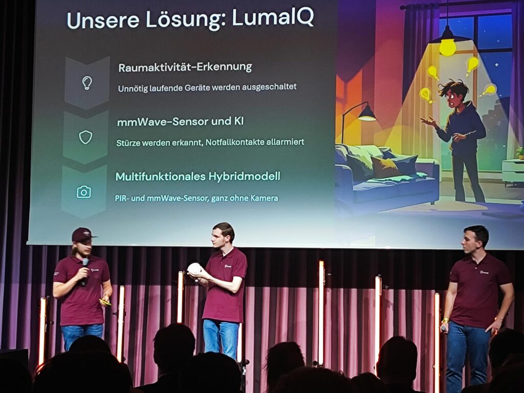 Drei Personen präsentieren eine Lösung namens LumalIQ auf einer Bühne.