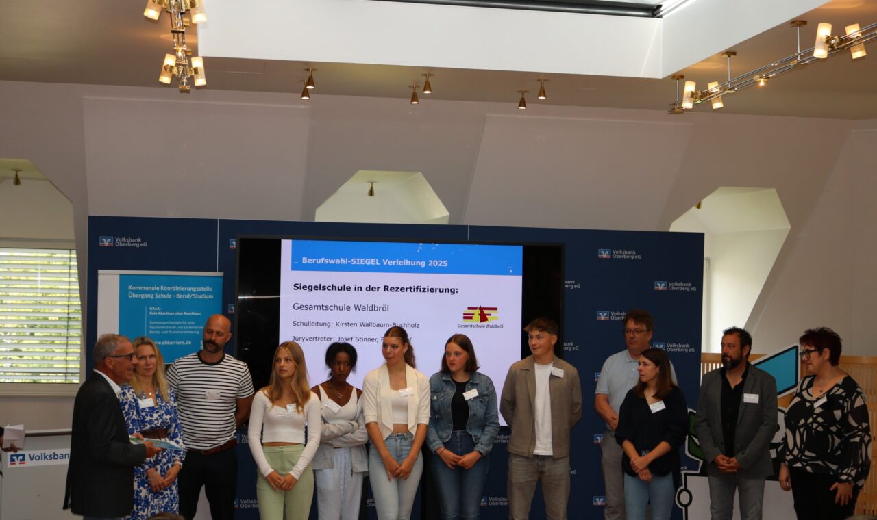 Gruppenbild von Teilnehmern einer Veranstaltung mit Präsentation im Hintergrund.