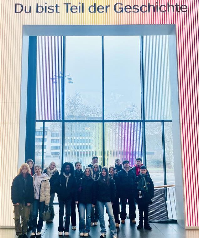 Gruppe von Schüler:innen der 10. Klassen der Gesamtschule Waldbröl vor der Installation mit der Aufschrift ‚Du bist Teil der Geschichte‘ im Haus der Geschichte in Bonn.