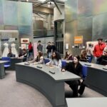 Schüler:innen der 10. Klassen der Gesamtschule Waldbröl nehmen im nachgebildeten Plenarsaal des ehemaligen Bundestages im Haus der Geschichte Platz und erleben eine Probeabstimmung.