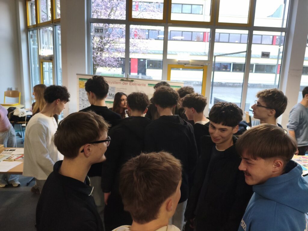 Gruppe von Schülern, die sich in einem Raum unterhalten.