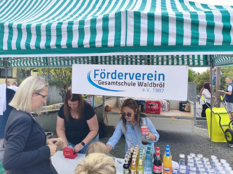 Stand des Fördervereins mit Getränken und einer Kassiererin. Kunden werden bedient.