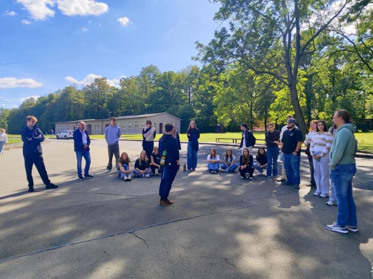 Gruppendiskussion auf einem Schulhof bei sonnigem Wetter.