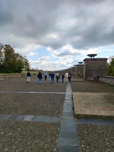 Gruppe von Menschen geht auf einem gepflasterten Weg in Richtung Horizon.