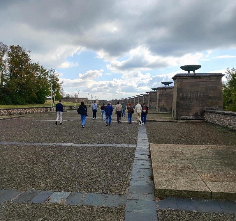 Gruppe von Menschen geht auf einem gepflasterten Weg in Richtung Horizon.