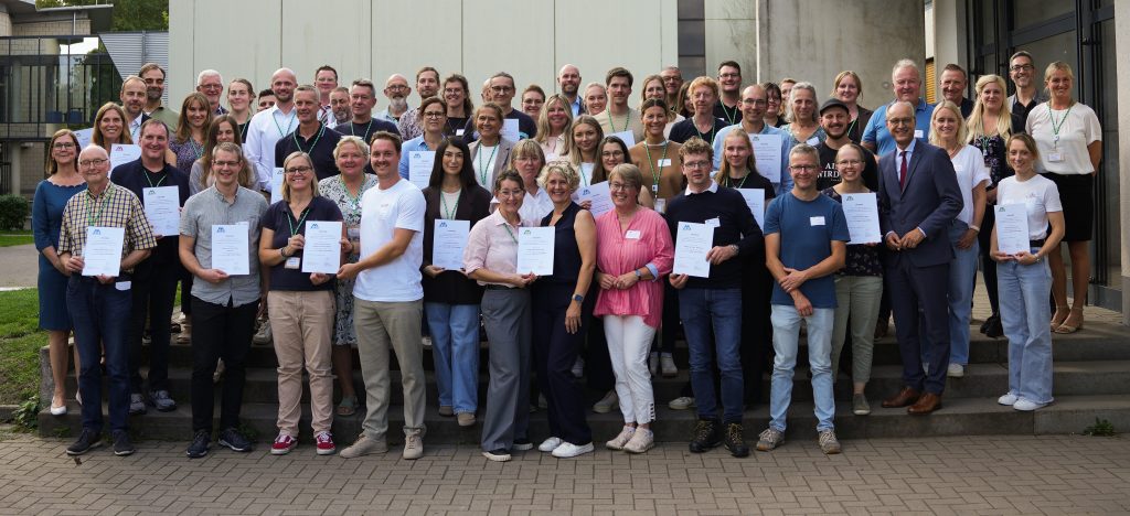 Gruppenfoto aller 2026 rezertifizierten MINT-Schulen NRW mit ihren Urkunden.